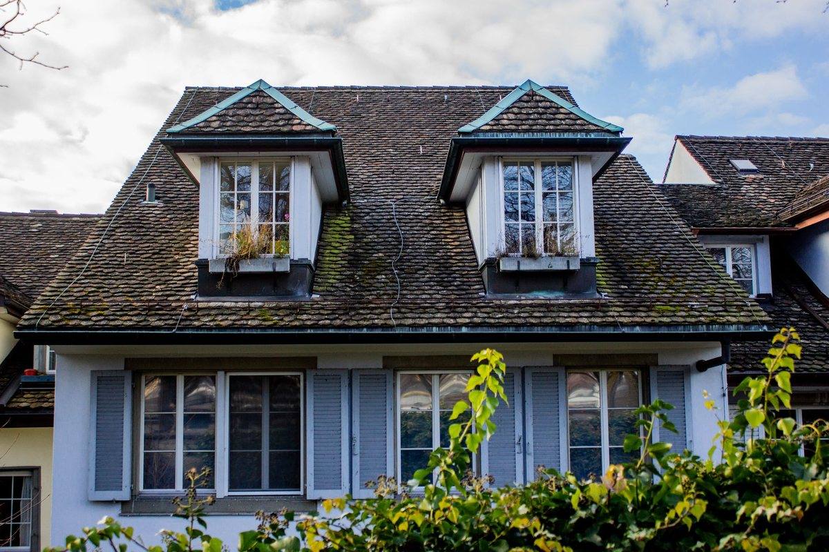 A house with two dormer windows set into a slate roof