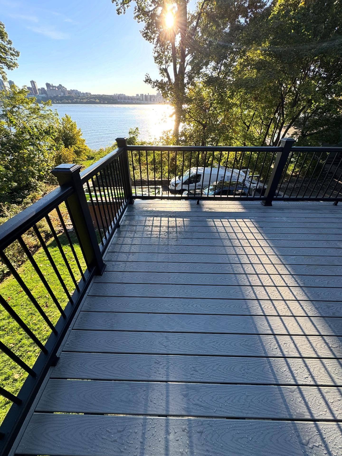 A new gray Trex deck with black railings overlooking the Hudson River in Edgewater