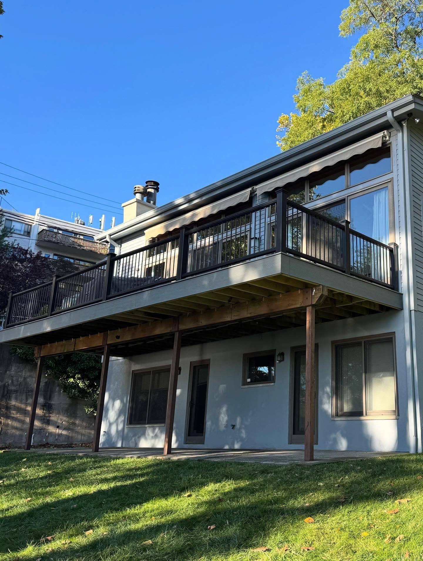 The rear of the Edgewater house after: light gray paint and the rebuilt Trex deck with black rails