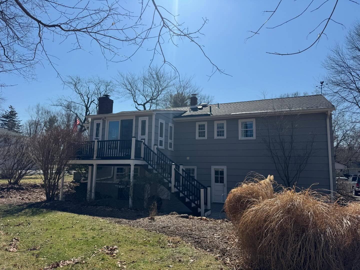 The rear of the Franklin Lakes split-level after the re-roof, new GAF Charcoal shingle over the whole house and the raised deck below it