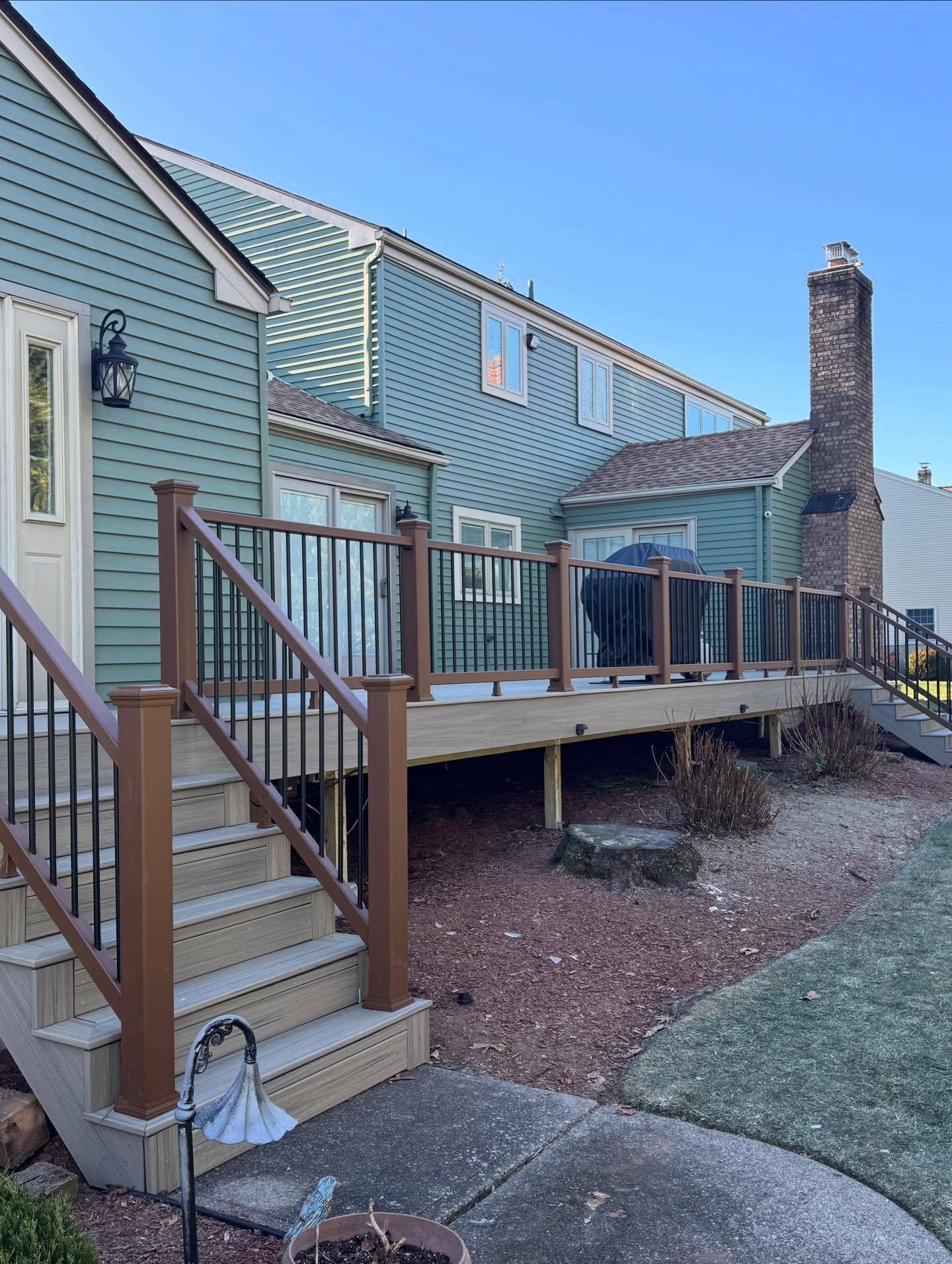 The finished Oradell deck in dark Trex composite with black railings and new stairs