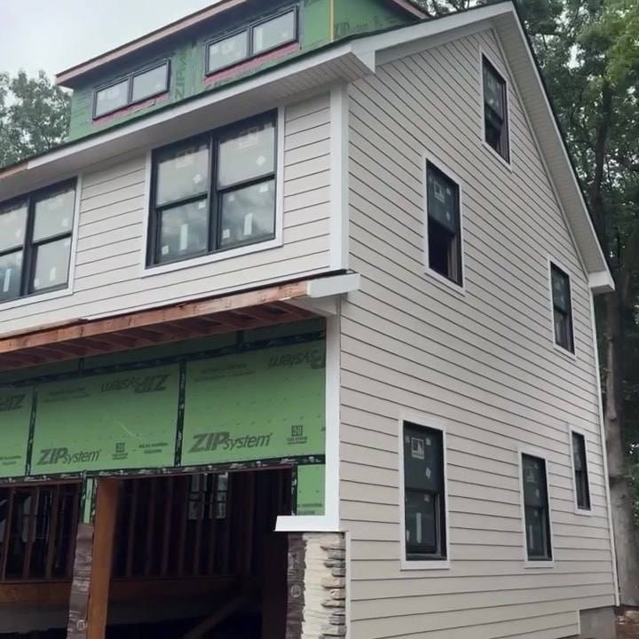 A new house we are building in Wyckoff, lap siding and black windows going on over ZIP System sheathing