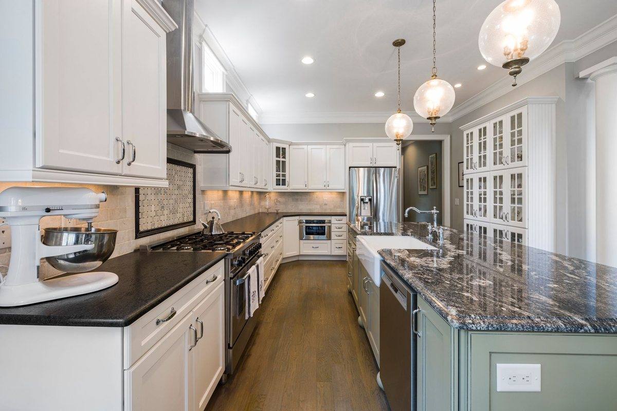 A white galley kitchen with stone counters