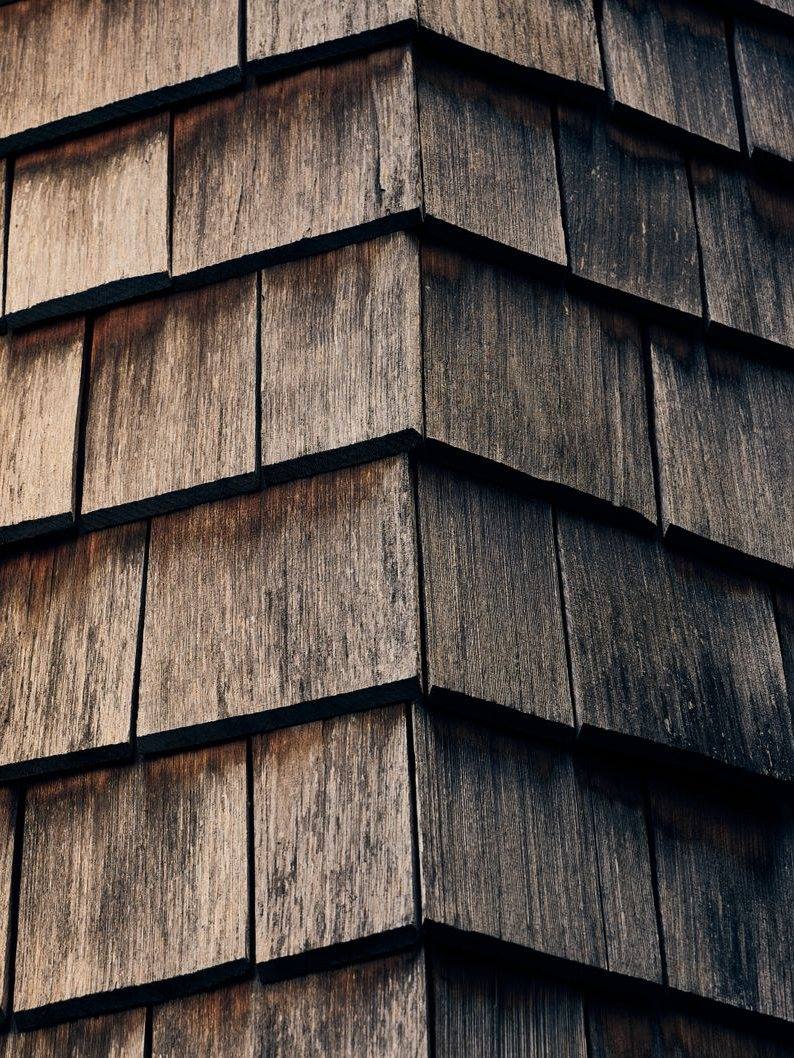 Overlapping cedar shake shingles on a roof edge