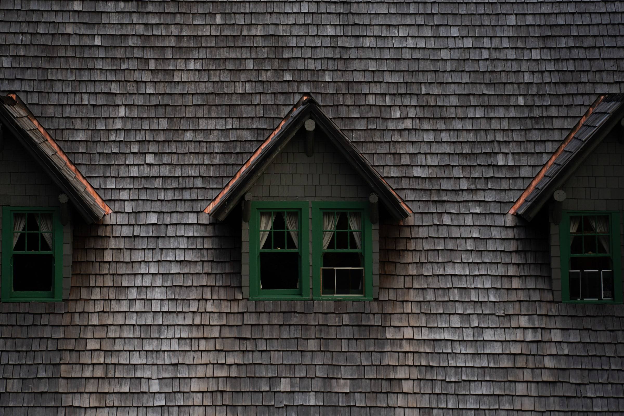 Three dormers with copper step flashing set into a weathered shingled roof plane