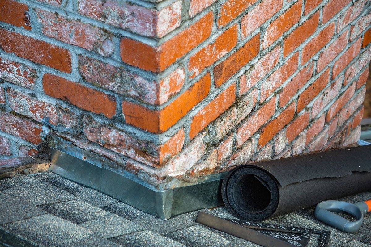 New flashing and a roll of membrane at a brick wall junction