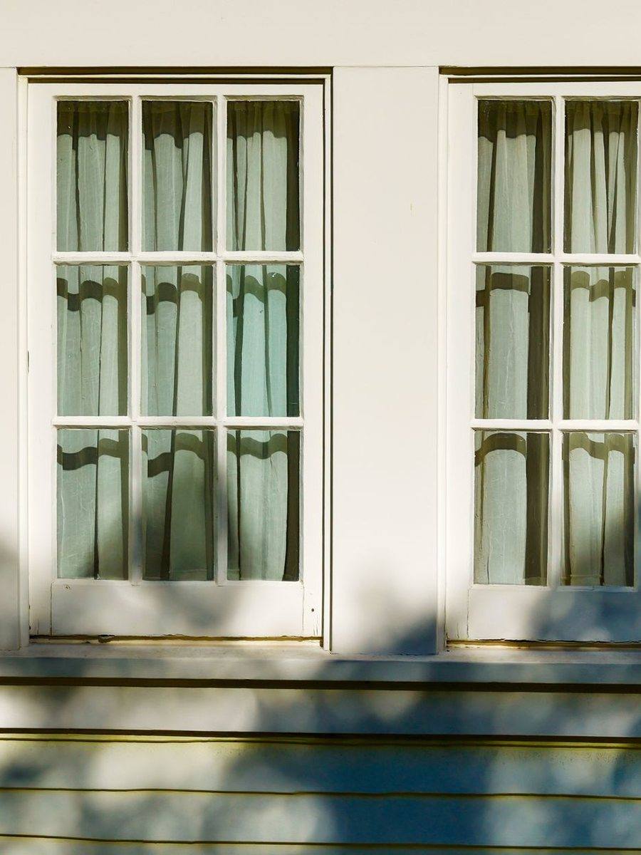 White painted clapboard with tall shuttered windows