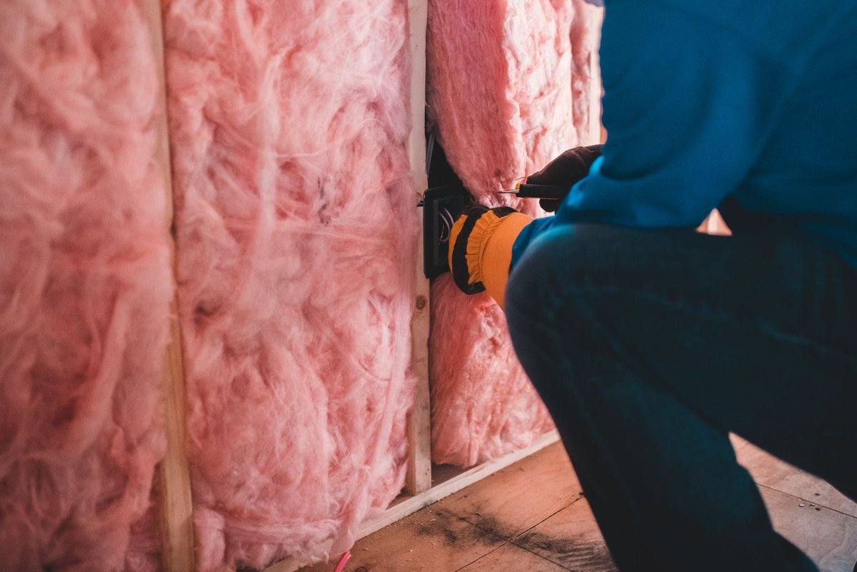 Insulation being fitted into an open stud wall during construction