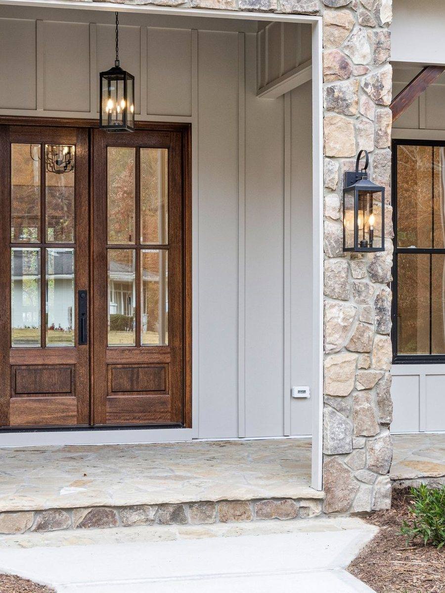 A wood entry door with sidelights set in a stone surround