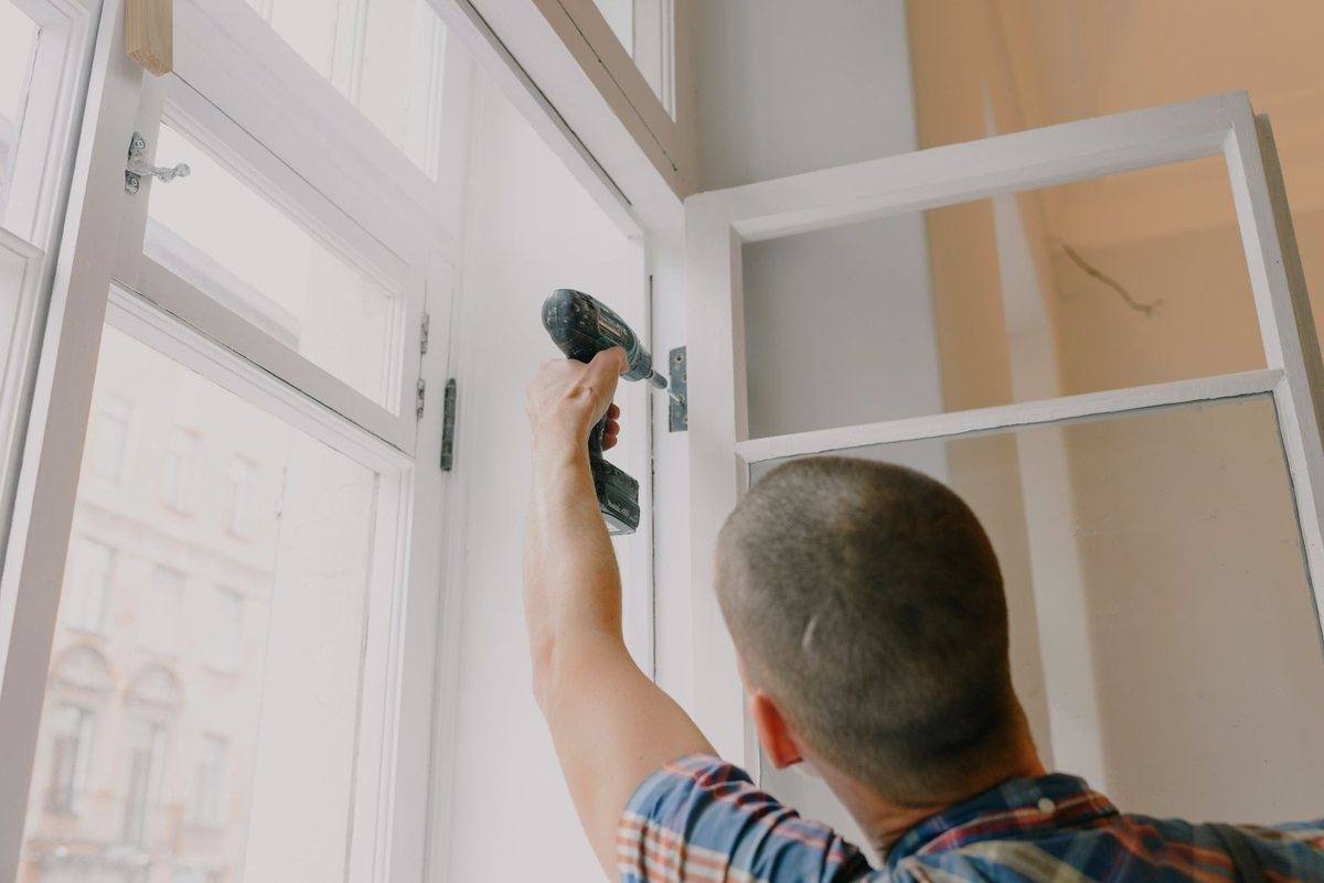 A joiner fixing a new window unit into a prepared opening